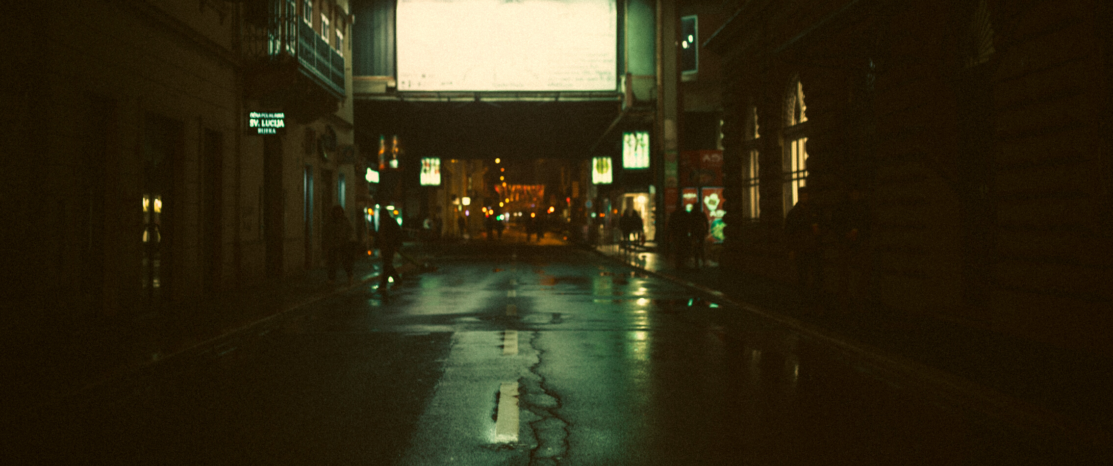 People Walking on Sidewalk during Night Time